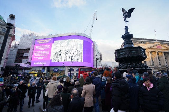 People holding memorial candles at Piccadilly Circus