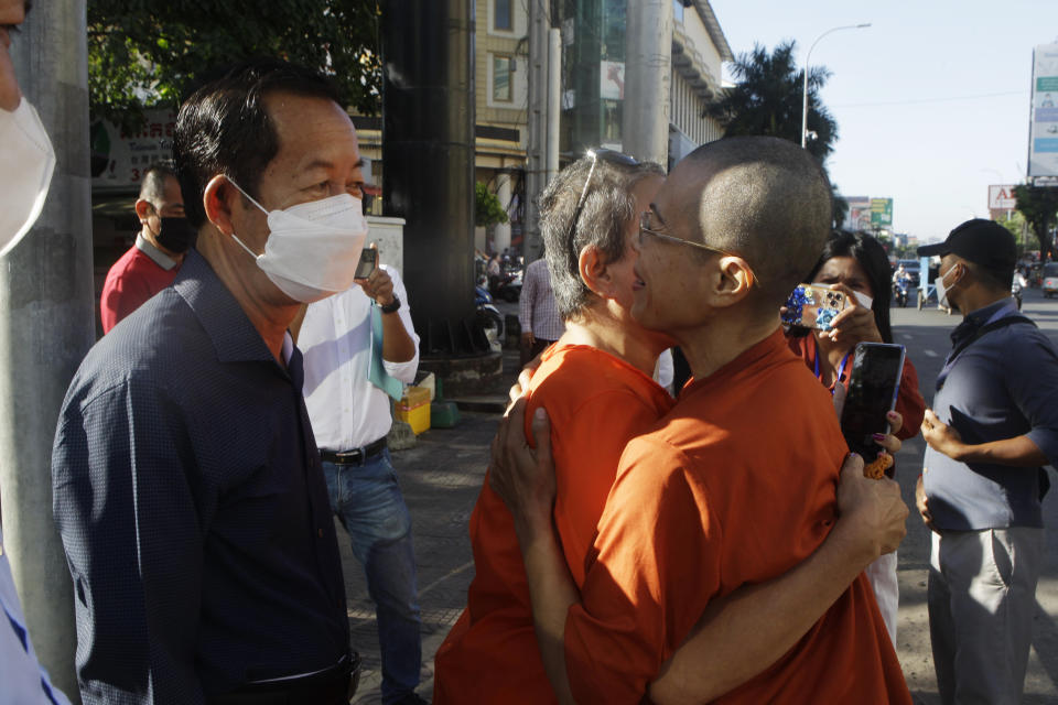 Theary Seng, right, a Cambodian-American lawyer, dressed in a prison-style orange outfit, hugs her supporter as she arrived at Phnom Penh Municipal Court in Phnom Penh, Cambodia, Tuesday, Jan. 4, 2022. Cambodian security forces on Tuesday briefly detained Theary, a prominent rights activist, as she walked barefoot near the prime minister’s residence in Phnom Penh, wearing the orange outfit and Khmer Rouge-era ankle shackles. She was released, shortly afterwards, and arrived at the Phnom Penh court for the resumption of her trial on treason charges. (AP Photo/Heng Sinith)