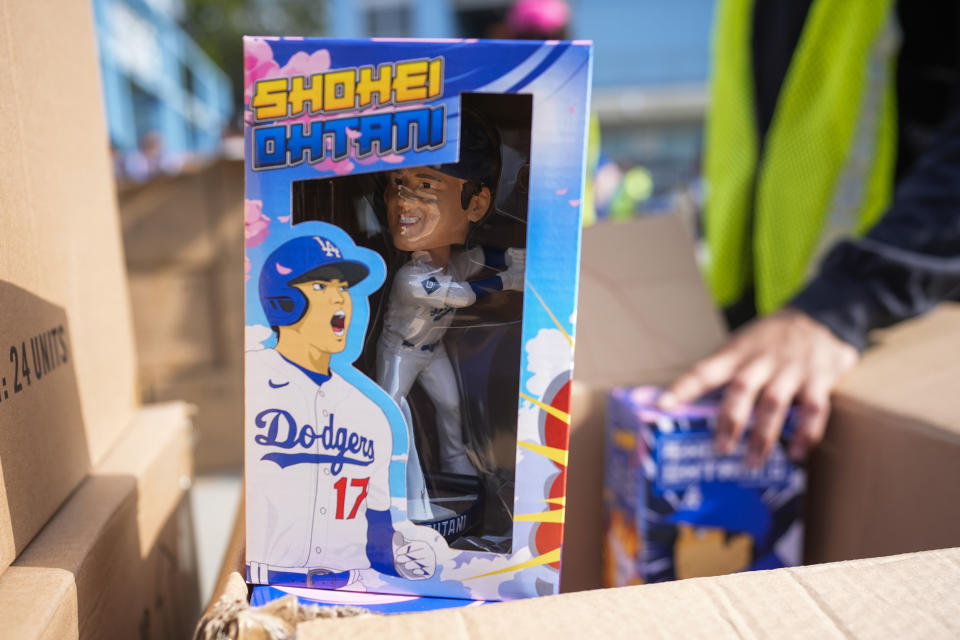 Bobbleheads of Los Angeles Dodgers designated hitter Shohei Ohtani are given to fans before a baseball game against the Cincinnati Reds in Los Angeles, Thursday, May 16, 2024. (AP Photo/Ashley Landis)