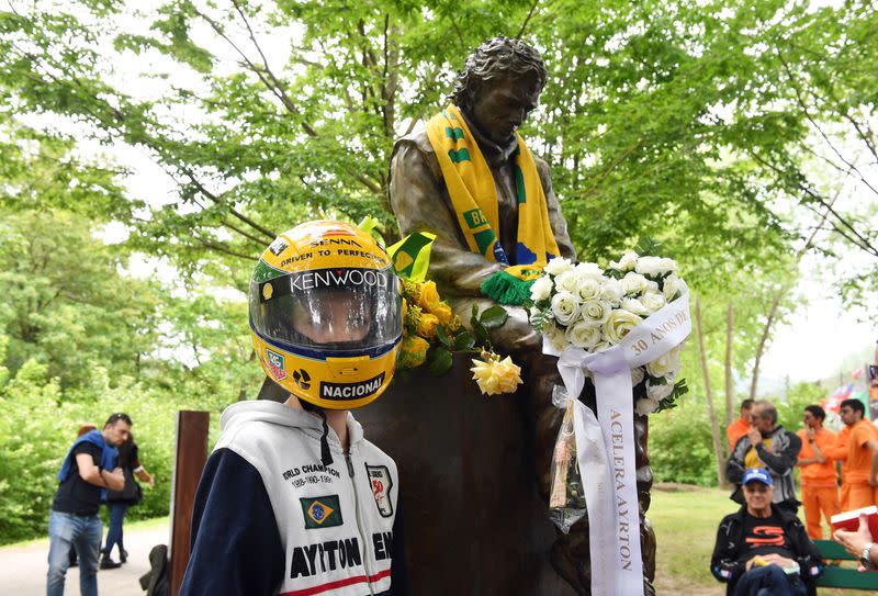 Un joven aficionado posa junto a un monumento al piloto brasileño de Fórmula Uno Ayrton Senna en el aniversario 30 de su muerte