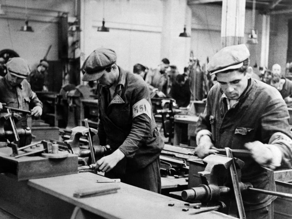 "Ostarbeiter" workers (Nazi term used to describe foreign slave workers from Eastern Europe) in an armaments factory in South Germany wearing armlets as markings.