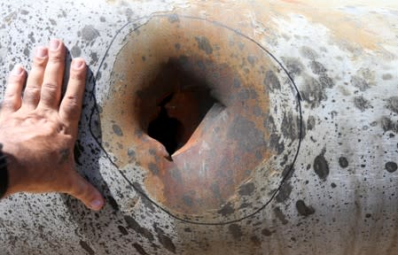 A hole in a damaged pipeline is seen at Saudi Aramco oil facility in Khurais