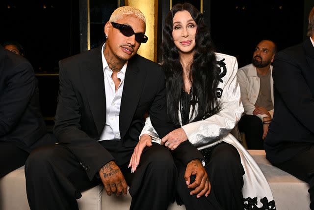 <p>Stephane Cardinale - Corbis/Corbis via Getty</p> Alexander "AE" Edwards and Cher at Balmain show during Paris Fashion Week in September 2023