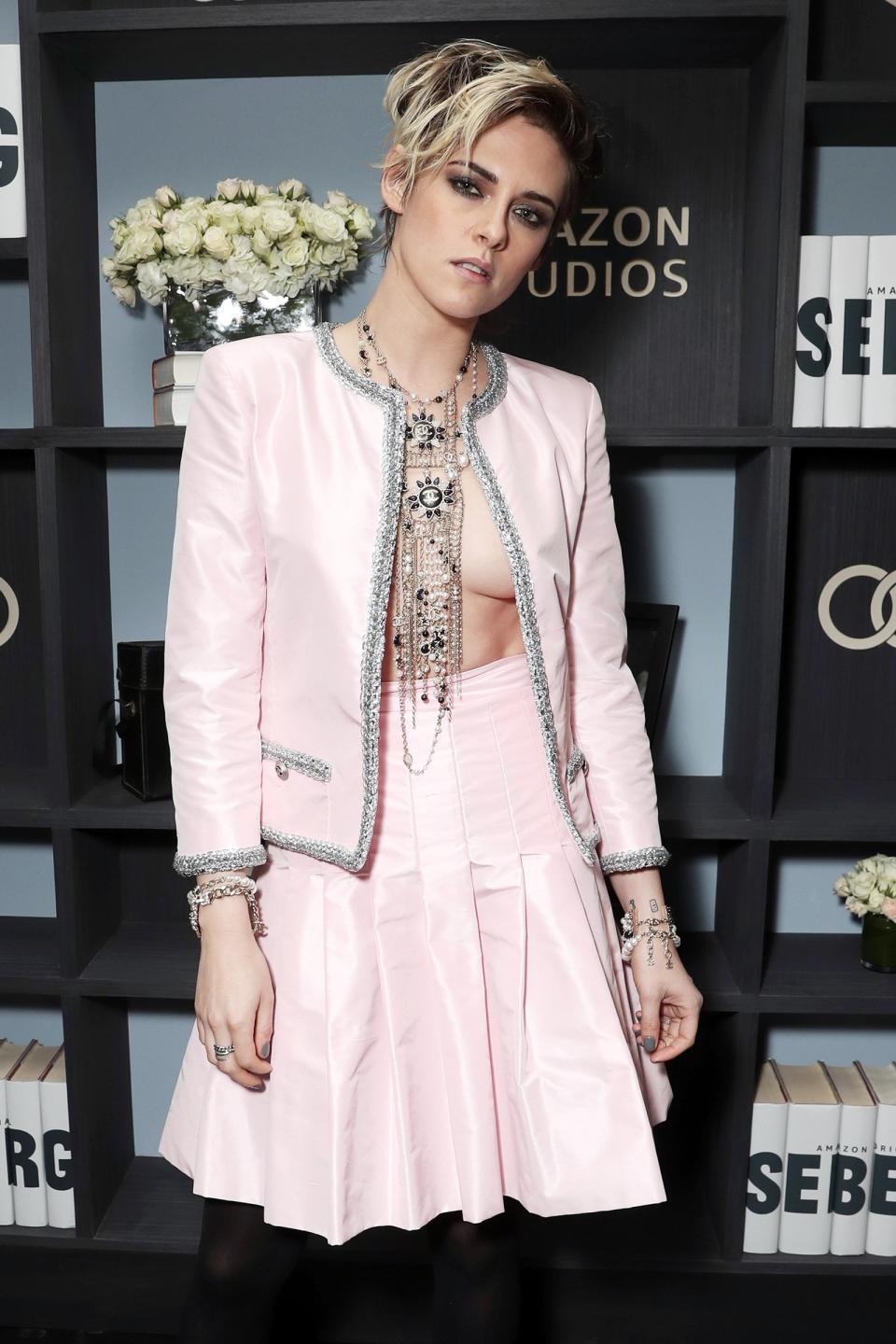 Kristen Stewart skips the shirt and stuns in a pale pink skirt and jacket as well as a dangling necklace at the Audi-sponsored screening of <i>Seberg</i> on Tuesday in L.A. 