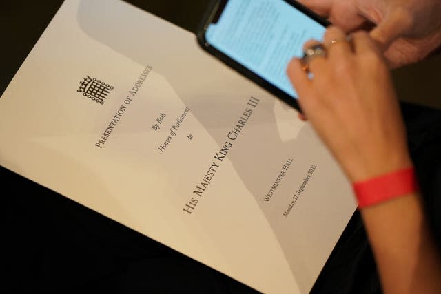 A person holds a copy of the order of events ahead of the arrival of King Charles III and the Queen Consort at Westminster Hall