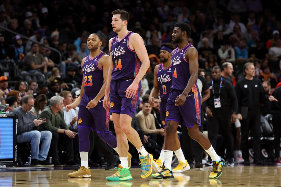 Phoenix Suns forward Drew Eubanks (14), guard Eric Gordon (23), forward Chimezie Metu (4), and guard Jordan Goodwin (0) walk back to the bench after a time-out against the Washington Wizards during the first half at Footprint Center in Phoenix on Dec. 17, 2023.