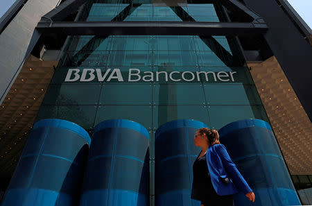 A woman walks past the BBVA building after people were evacuated from the Mexican headquarters of Spain's BBVA due to what the bank said were two anonymous emails threatening violent acts against its corporate offices, in Mexico City, Mexico March 13, 2019. REUTERS/Henry Romero