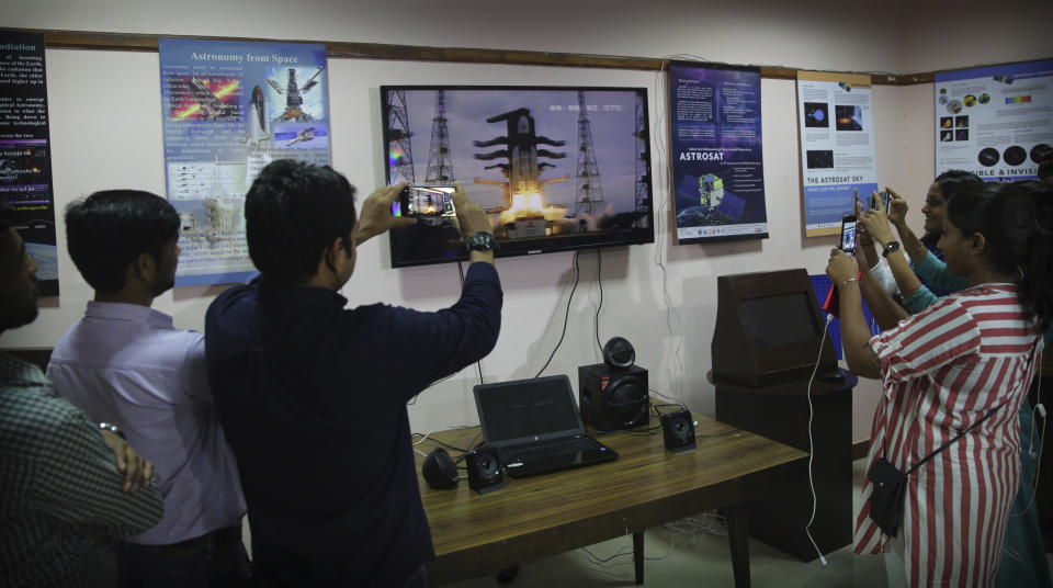 Indians at New Delhi's Nehru Planetarium, watch a web cast of the lift off of Indian Space Research Organization (ISRO)'s Geosynchronous Satellite launch Vehicle (GSLV) MkIII carrying Chandrayaan-2 from Satish Dhawan Space center in Sriharikota, India, Monday, July 22, 2019. India's space agency says it has launched an unmanned spacecraft to the far side of the moon a week after aborting the mission due to a technical problem. (AP Photo/Manish Swarup)