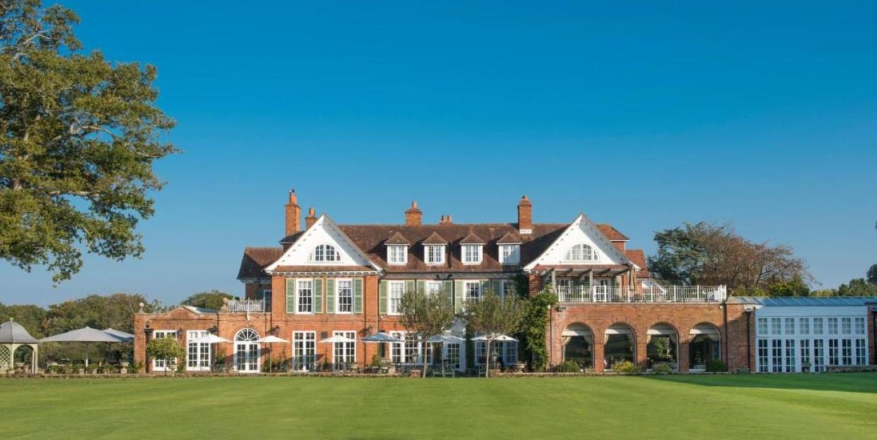 a large brick building with a lawn in front of it