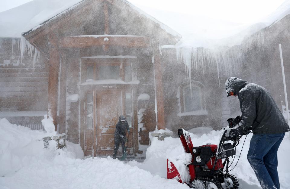 Residents clear out snow in front of their home on Donner Pass Road during a powerful multiple day winter storm in the Sierra Nevada mountains (Getty Images)