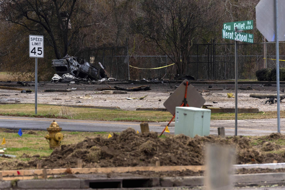 A view of a damaged vehicle near the site of a plane crash after a small plane crashed into the parking lot of a post office in Lafayette, La., Saturday, Dec. 28, 2019. Several people died in the crash. (Scott Clause/The Lafayette Advertiser via AP)