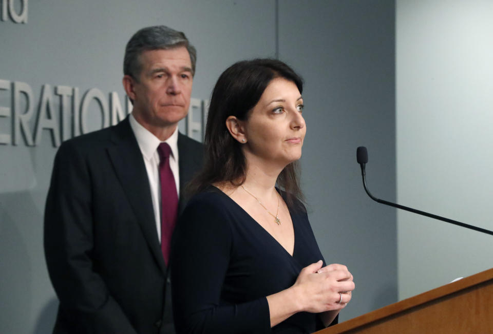 Dr. Mandy Cohen, secretary of the state Department of Health and Human Services, speaks during North Carolina Gov. Roy Cooper's, left, briefing on the coronavirus pandemic at the Emergency Operations Center in Raleigh, N.C., Thursday, May 28, 2020. (Ethan Hyman/The News & Observer via AP)