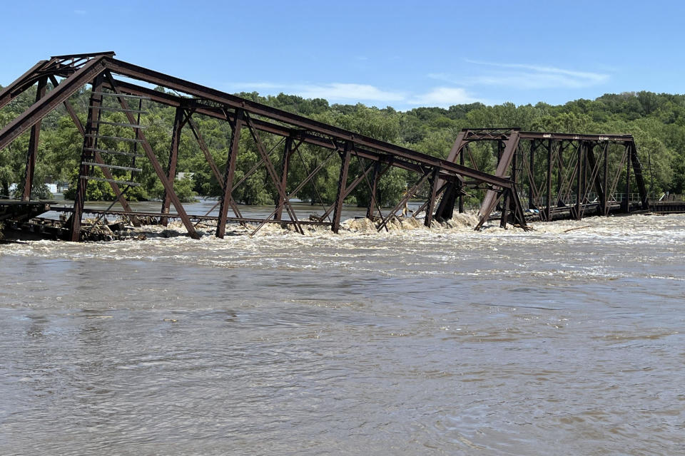 FILE - A railroad bridge connecting North Sioux City, S.D., with Sioux City, Iowa, is seen partially collapsed into the Big Sioux River due to flooding, June 24, 2024. Record flooding and powerful tornadoes ravaged parts of Iowa for weeks this spring, destroying or damaging thousands of homes, closing roads and bridges and costing over $130 million in infrastructure damage, officials said Thursday, July 11. (AP Photo/Margery A. Beck, File)