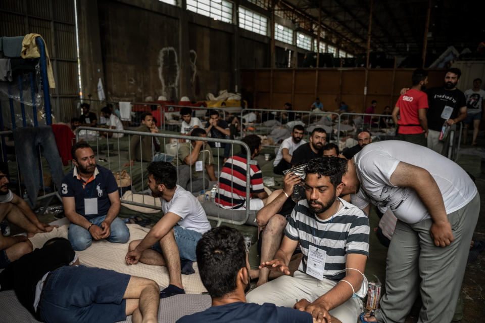 Rescued migrants sit inside a warehouse in Kalamata, Greece on June 15, 2023. / Credit: Angelos Tzortzinis/Afp/Pool/Anadolu Agency via Getty Images