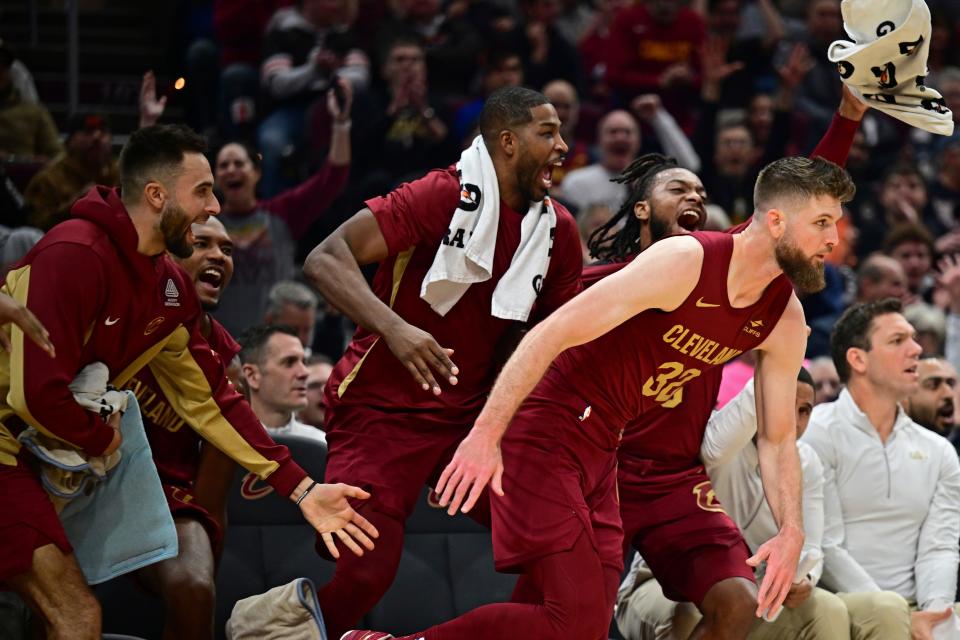 Cleveland Cavaliers forward Dean Wade is congratulated by teammates on the bench after a there point basket in the first half of an NBA basketball game against the Denver Nuggets, Sunday, Nov. 19, 2023, in Cleveland. (AP Photo/David Dermer)