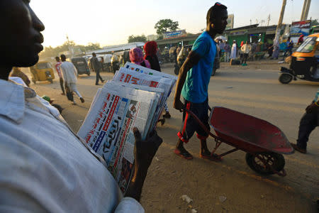 A vender carries news papers in Nyala market, during Sudanese President Omar al-Bashir visit to the war-torn Darfur region, in Nyala, Darfur, Sudan September 19, 2017. REUTERS/Mohamed Nureldin Abdallah