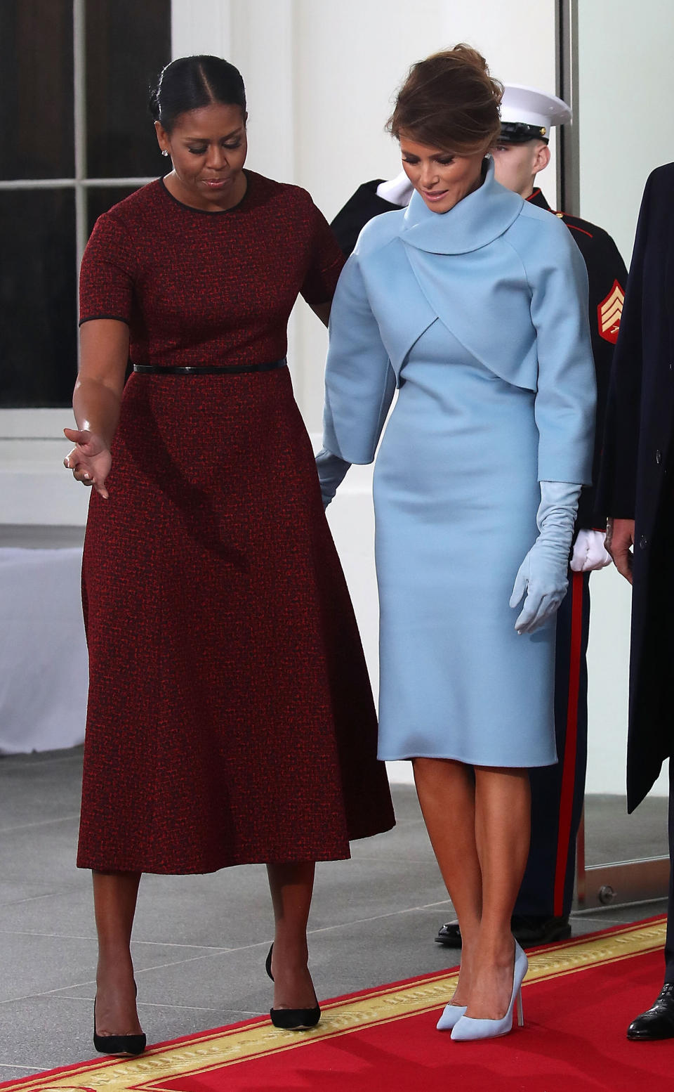 The outgoing first lady guides Melania Trump on a red carpet at the White House the morning of Donald Trump's 2017 inauguration.