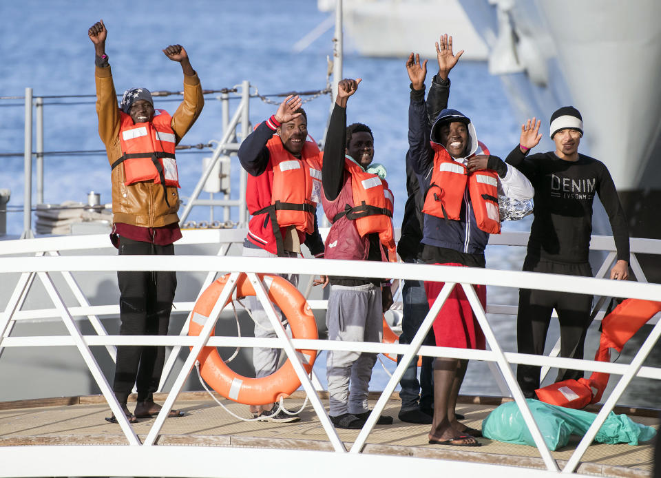 Migrants wave as they disembark at Hay Wharf, Pieta, Malta, Wednesday, Jan. 9, 2019. The 49 rescued migrants who were stranded at sea since last month were brought to Malta and then distributed among eight European Union countries. The deal, announced by Maltese Prime Minister Joseph Muscat, breaks a stalemate that began after 32 were rescued by a German aid group's vessel on Dec. 22. The other 17 were rescued on Dec. 29 by a different aid boat. Both Italy and Malta have refused to let private rescue ships bring migrants to their shores. (AP Photo/Rene Rossignaud)