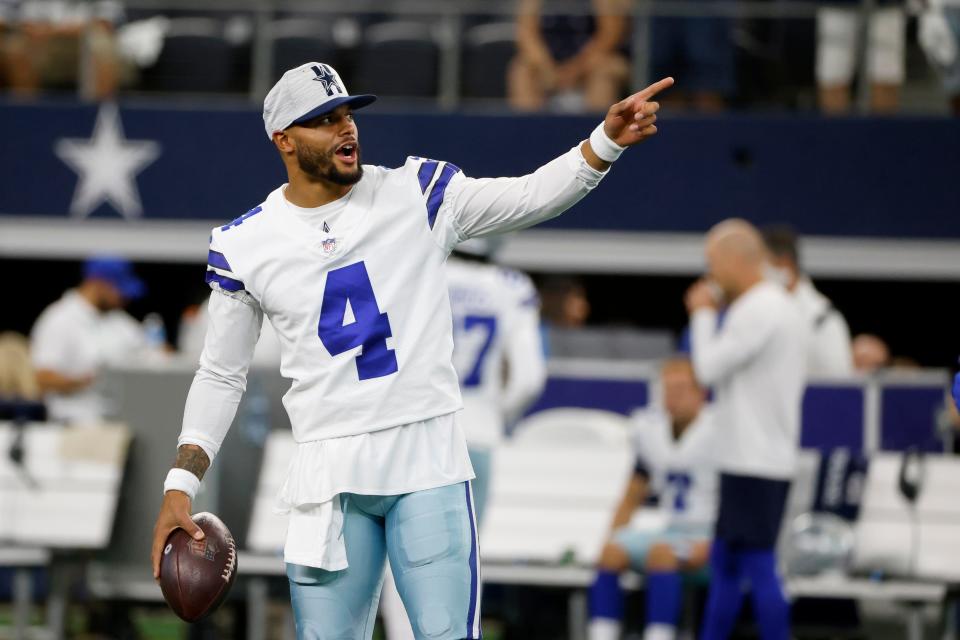 Dallas Cowboys' Dak Prescott gestures as he stands on the field during warmups before a preseason NFL football game against the Houston Texans in Arlington, Texas, Saturday, Aug. 21, 2021.