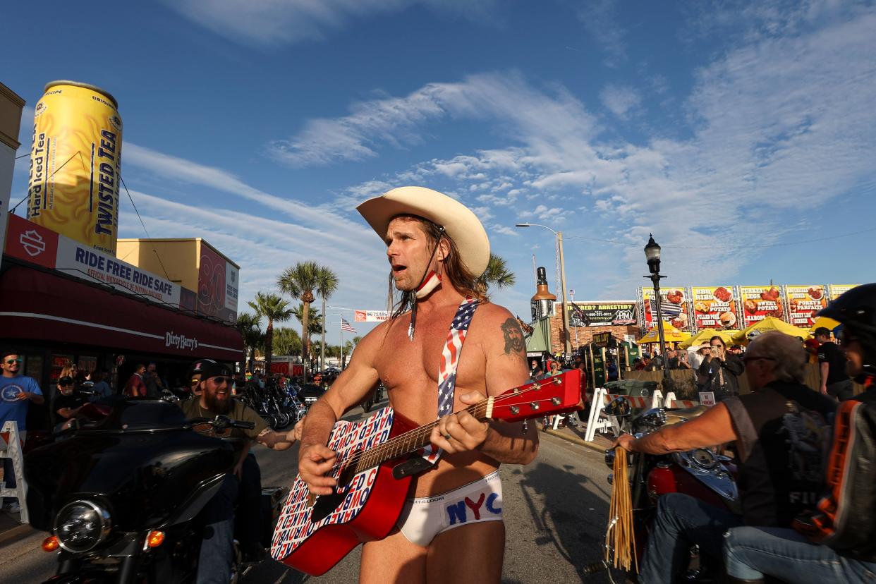 Robert Burck, better known as the Naked Cowboy, walks down the middle of Main Street while performing in Daytona, Fla., during the start of Bike Week on Friday, March 5, 2021. Police arrested the Times Square performer on a misdemeanor resisting arrest charge and cited him for panhandling as he worked a gig at Bike Week.  (Sam Thomas/Orlando Sentinel via AP) (AP)