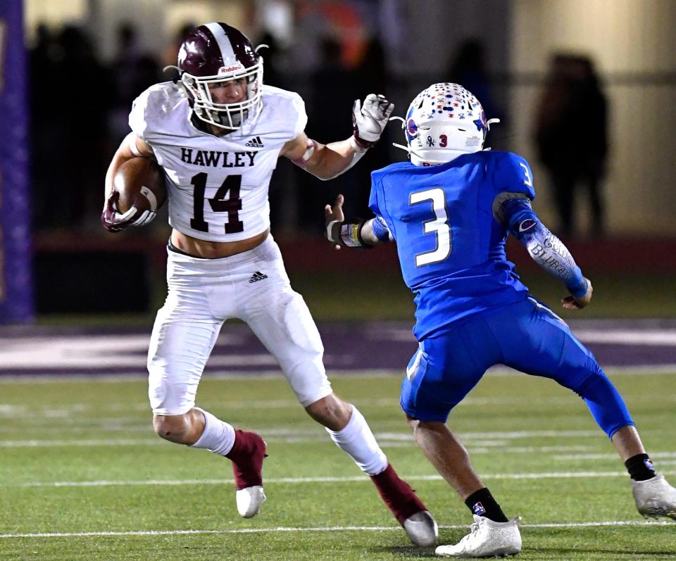 Hawley wide receiver Kason O'Shields stiff-arms Coleman defensive back Devinar Roberson during Friday's Region I-2A Division I semifinals game.