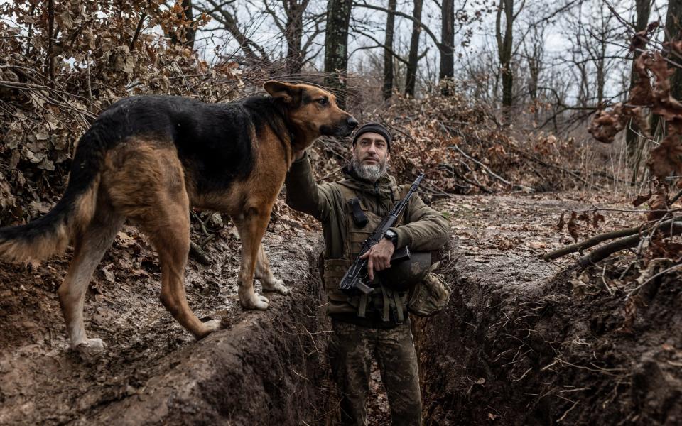 Ukrainian soldier is seen with his dog in a trench near Gorlivka in Donetsk