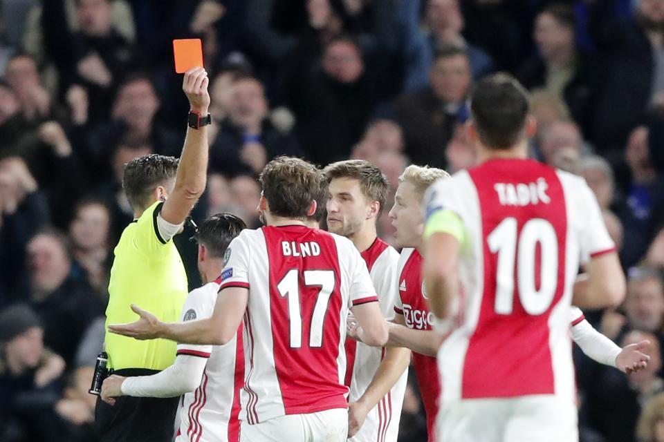 Referee Gianluca Rocchi shows a red card to Ajax's Daley Blind during the group H Champions League soccer match between Chelsea and Ajax at Stamford Bridge in London, Tuesday, Nov. 5, 2019. (AP Photo/Frank Augstein)