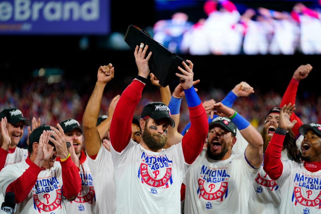 Philadelphia Phillies designated hitter Bryce Harper celebrates with the trophy after winning the baseball NL Championship Series in Game 5 against the San Diego Padres on Sunday, Oct. 23, 2022, in Philadelphia. (AP Photo/Matt Slocum)