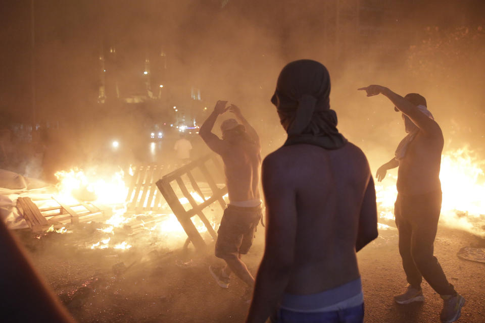 Anti-government protesters set fire to plastic barriers and trash to block a road during a demonstration in Beirut, Lebanon, Thursday, Oct. 17, 2019. Scores of people are protesting in Beirut and other parts of Lebanon over the government's plans to impose new taxes amid a harsh economic crisis in the country. (AP Photo/Hassan Ammar)