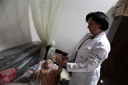 Cuban doctor Elisa Barrios Calzadilla inspects a patient during a house call in the city of Itiuba in the state of Bahia, northeastern Brazil November 20, 2013. REUTERS/Ueslei Marcelino