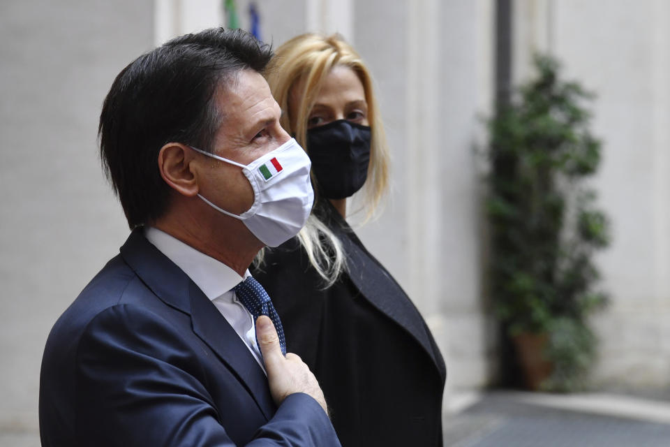 FILE - In this Saturday, Feb. 13, 2021 file photo, Italy's outgoing Premier, Giuseppe Conte and his partner Olivia Paladino pose and acknowledge the applause of the employees of Chigi Palace Premier's office in Rome. When Giuseppe Conte exited the premier’s office, palace employees warmly applauded in him appreciation. But that’s hardly likely to be Conte’s last hurrah in politics. Just a few hours after the handover-ceremony to transfer power to Mario Draghi, the former European Central Bank chief now tasked with leading Italy in the pandemic, Conte dashed off a thank-you note to citizens that sounded more like an ’’arrivederci″ (see you again) then a retreat from the political world he was unexpectedly propelled into in 2018.(Alberto Pizzoli/Pool via AP, File)