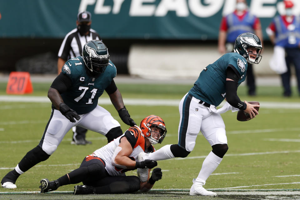 Philadelphia Eagles' Carson Wentz (11) is grabbed by Cincinnati Bengals' Sam Hubbard (94) during the first half of an NFL football game, Sunday, Sept. 27, 2020, in Philadelphia. (AP Photo/Laurence Kesterson)