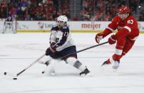 Columbus Blue Jackets left wing Johnny Gaudreau (13) is pursued by Detroit Red Wings defenseman Moritz Seider (53) during the second period of an NHL hockey game Tuesday, March 19, 2024, in Detroit. (AP Photo/Duane Burleson)