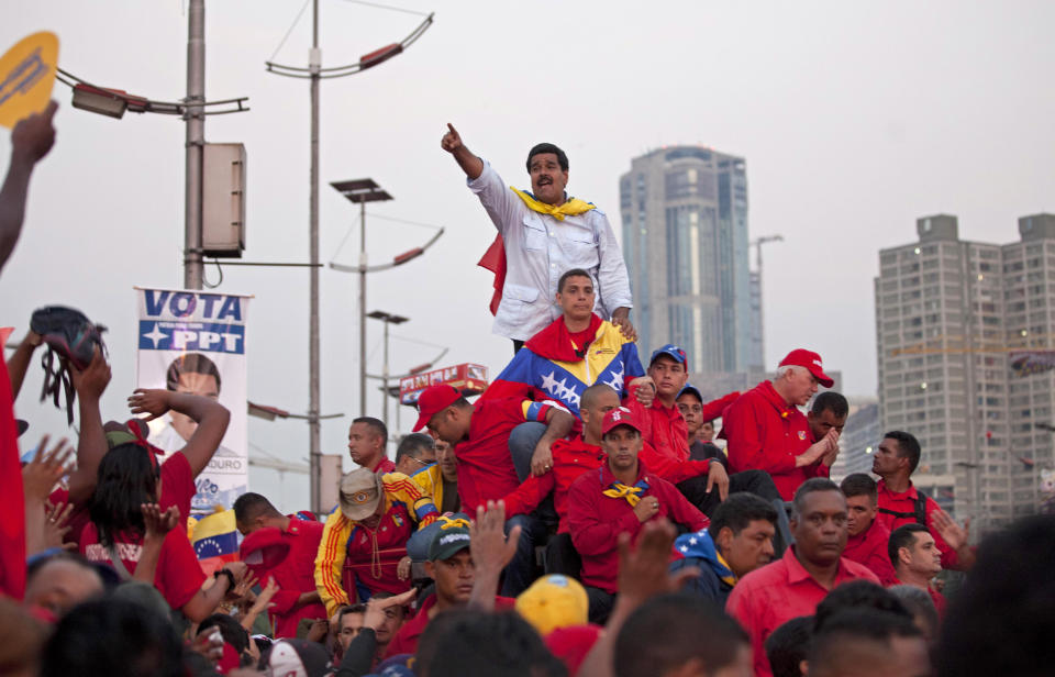 ARCHIVO - El aspirante a presidente de Venezuela Nicolás Maduro saluda a sus simpatizantes a su llegada a la avenida Bolívar para un acto de cierre de campaña en Caracas, Venezuela, el 11 de abril de 2013. Maduro, el sucesor del fallecido mandatario Hugo Chávez, ganó al candidato de la oposición Henrique Capriles en las elecciones del 14 de abril. (AP Foto/Ramón Espinosa, Archivo)