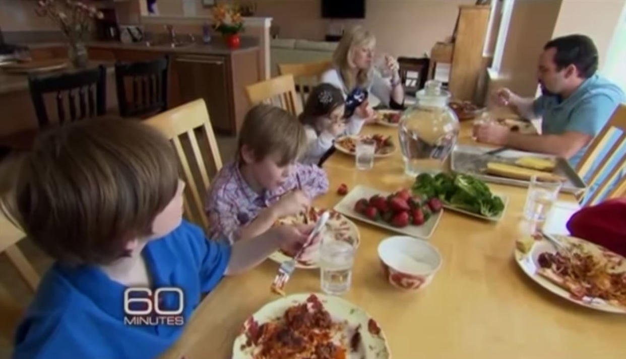 Michael and Kristine Barnett eating dinner with four kids at the table in 2012 during a segment for 60 Minutes.