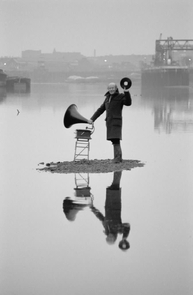 british radio broadcaster roy plomley with an old fashioned gramophone on a patch of dry land in the thames near the bottom of his garden