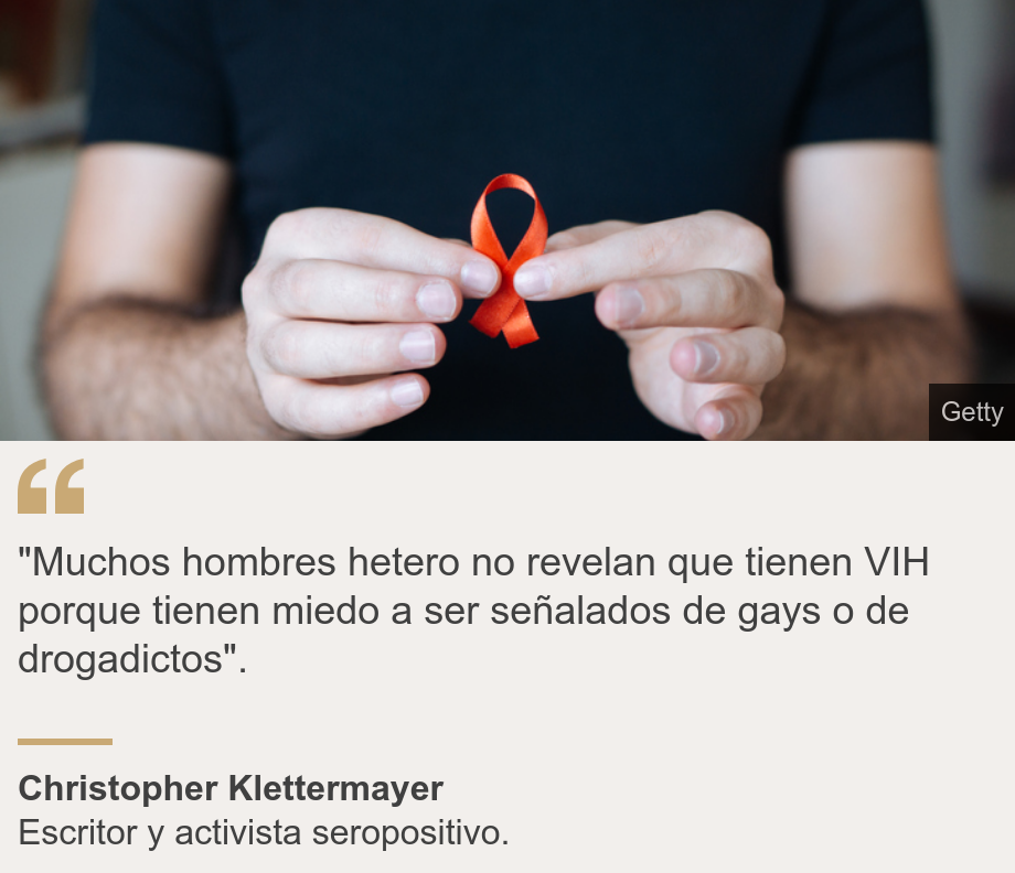 ""Muchos hombres hetero no revelan que tienen VIH porque tienen miedo a ser señalados de gays o de drogadictos". ", Source: Christopher Klettermayer, Source description: Escritor y activista seropositivo. , Image: Un hombre sosteniendo un lazo rojo, símbolo de la lucha contra el sida. 