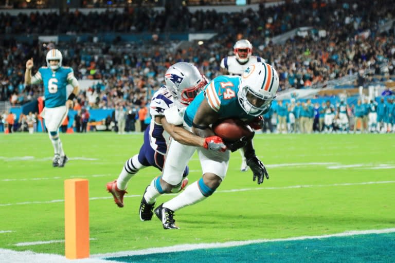 Jarvis Landry of the Miami Dolphins scores a touchdown in the second quarter against the defense of Jonathan Jones of the New England Patriots