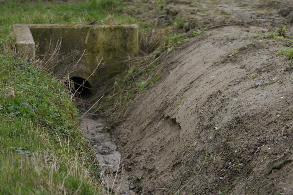 A stormdrain on the side of a field of crops in West Flanders, Belgium, Wednesday, Feb. 21, 2024. After hundreds of tractors disrupted an EU summit in Brussels in early February, farmers plan to return on Monday to be there when farm ministers discuss an emergency item on the agenda; simplification of agricultural rules that some fear could also amount go a weakening of standards. (AP Photo/Virginia Mayo)