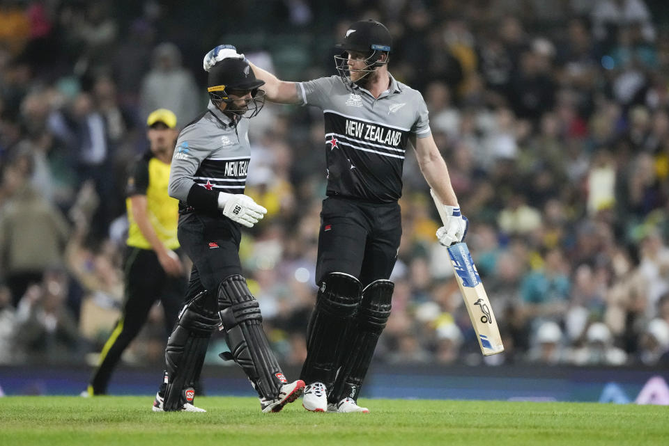 New Zealand's Devon Conway, left, is congratulated by teammate James Neesham as they leave the field after their innings during the T20 World Cup cricket match between Australia and New Zealand in Sydney, Australia, Saturday, Oct. 22, 2022. (AP Photo/Rick Rycroft)