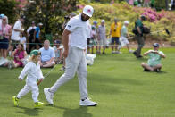 Jon Rahm, of Spain, walks with his son, Kepa, on the second hole during the par-3 contest at the Masters golf tournament at Augusta National Golf Club Wednesday, April 10, 2024, in Augusta, GA. (AP Photo/Ashley Landis)