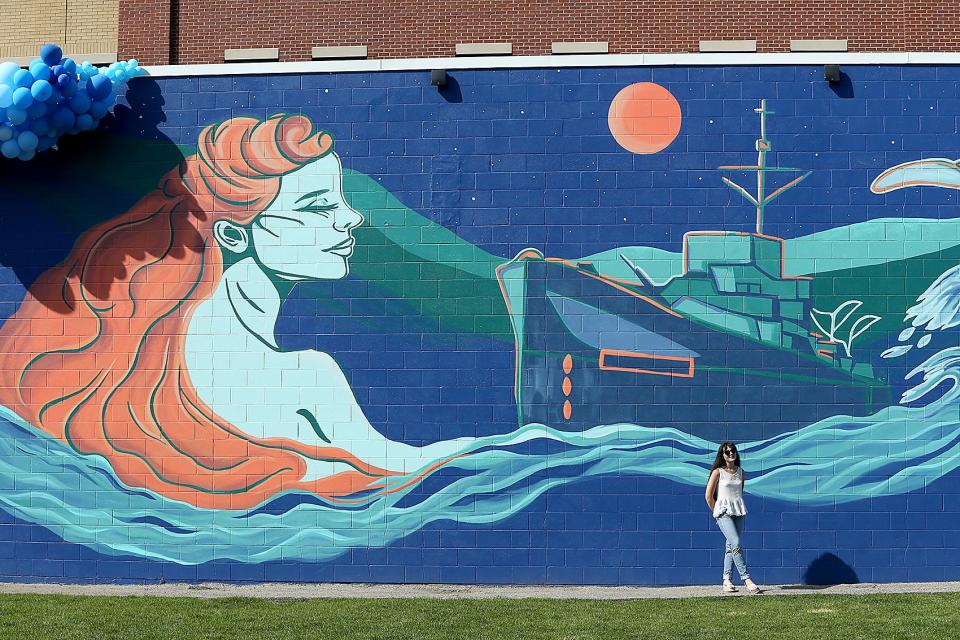 Olivia Rose James stands in front of her most recent mural.