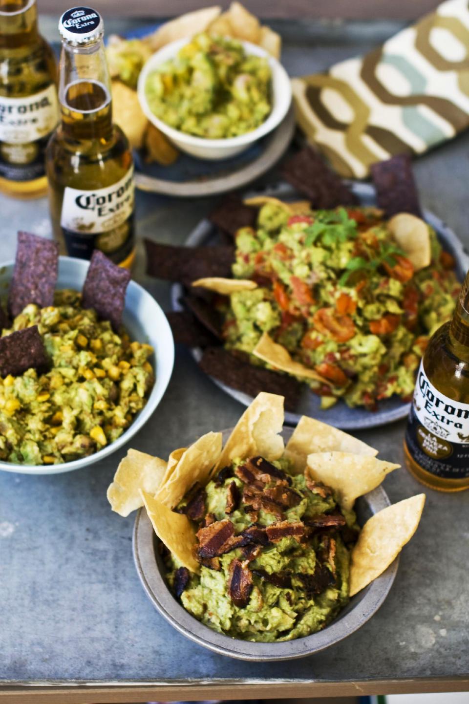 In this image taken on January 7, 2013, sweet heat bacon guacamole, front, chipotle corn guacamole, middle left, shrimp and mango guacamole, top, and roasted fresh salsa guacamole, middle right, are shown served in bowls in Concord, N.H. (AP Photo/Matthew Mead)