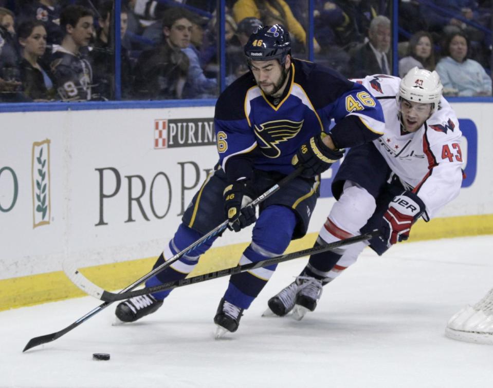 Washington Capitals' Tom Wilson (43) tries to poke the puck away from St. Louis Blues' Roman Polak (46) during the first period of an NHL hockey game, Tuesday, April 8, 2014, in St. Louis.(AP Photo/Tom Gannam)