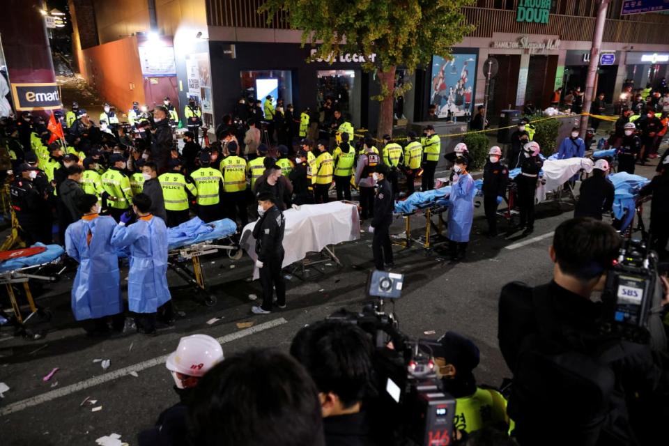 <div class="inline-image__caption"><p>Rescue team members wait with stretchers to remove bodies from the scene where dozens of people were killed in a stampede during a Halloween festival in Seoul.</p></div> <div class="inline-image__credit">KIM HONG-JI</div>