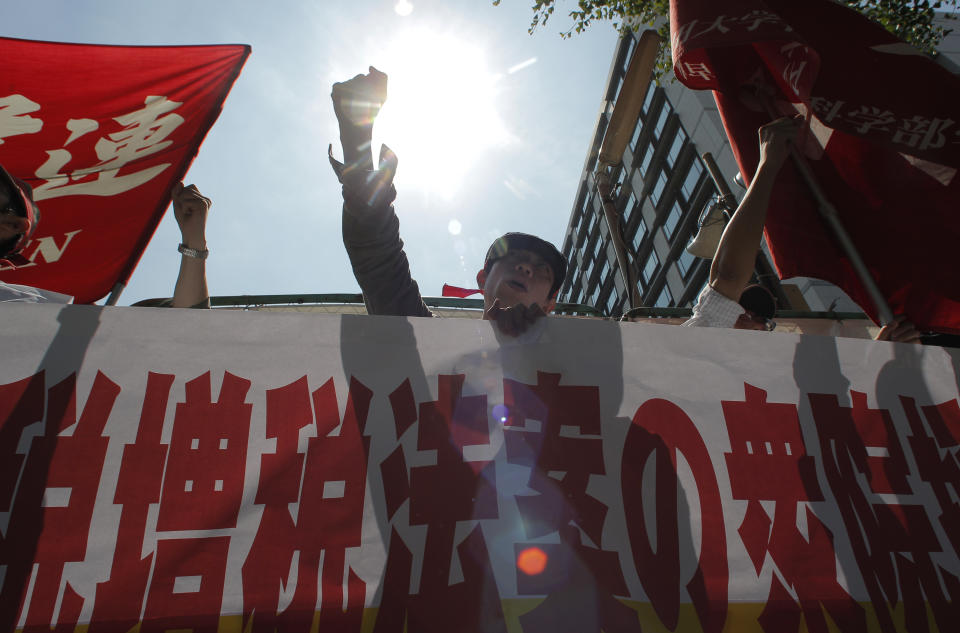 Demonstrators shout slogans during an anti-sales tax hike rally in front of the Diet building in Tokyo Tuesday, June 26, 2012. Japan's prime minister made a final plea for unity on a tax hike vote Tuesday that has divided his ruling party and could weaken his hold on power. The banner reads: We oppose the lower house passage of the tax hike bill. (AP Photo/Itsuo Inouye)