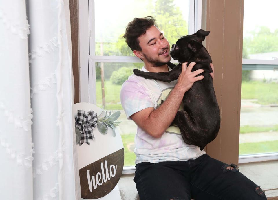 Beau Shaniuk holds his Boston Terrier puppy George in his  home. 