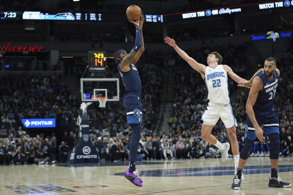 Minnesota Timberwolves forward Jaden McDaniels, left, shoots over Orlando Magic forward Franz Wagner (22) during the first half of an NBA basketball game, Friday, Feb. 2, 2024, in Minneapolis. (AP Photo/Abbie Parr)