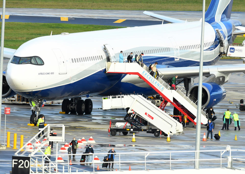 Passengers from aboard the Antarctica Cruise ship The Greg Mortimer arrive at Melbourne Airport from Uruguay, Sunday, April 12, 2020. More than 100 Australian and New Zealand passengers of the cruise ship, most of whom infected by the coronavirus, arrived in Melbourne early Sunday on a flight from Uruguay.(James Ross/AAP Image via AP)