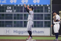 Cleveland Guardians' baseman Andres Gimenez, left, celebrates after his one-run RBI double next to Houston Astros second baseman Jose Altuve, right, during the third inning of a baseball game Thursday, May 2, 2024, in Houston. (AP Photo/Michael Wyke)